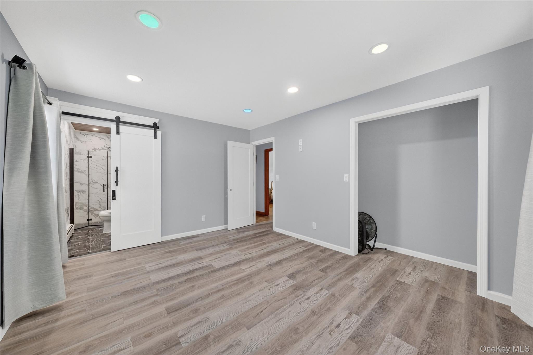 93 Old Mill Road Wallkill, NY 12589 - Photo 18 of 39 Unfurnished bedroom featuring a barn door, recessed lighting, light wood-type flooring, and ensuite bathroom