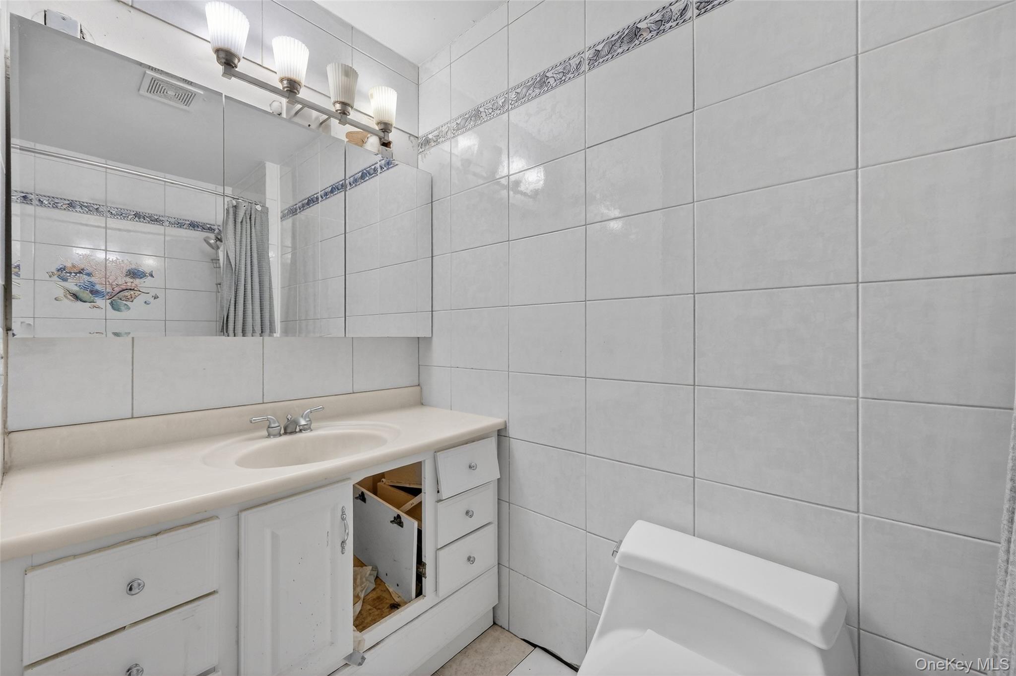 93 Old Mill Road Wallkill, NY 12589 - Photo 25 of 39 Bathroom with tile walls, a shower with shower curtain, and vanity