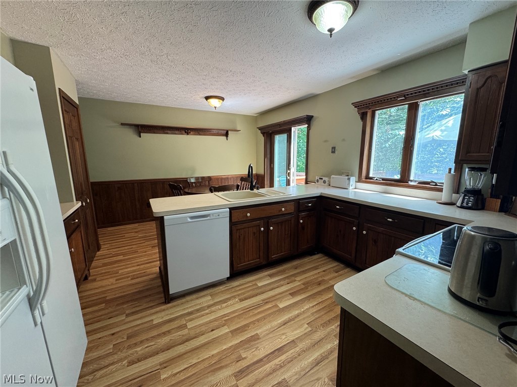 8201 Orchard Road Painesville, OH 44077 - Photo 11 of 45 Kitchen featuring wood-finish flooring, dark wood cabinetry and view of dining area