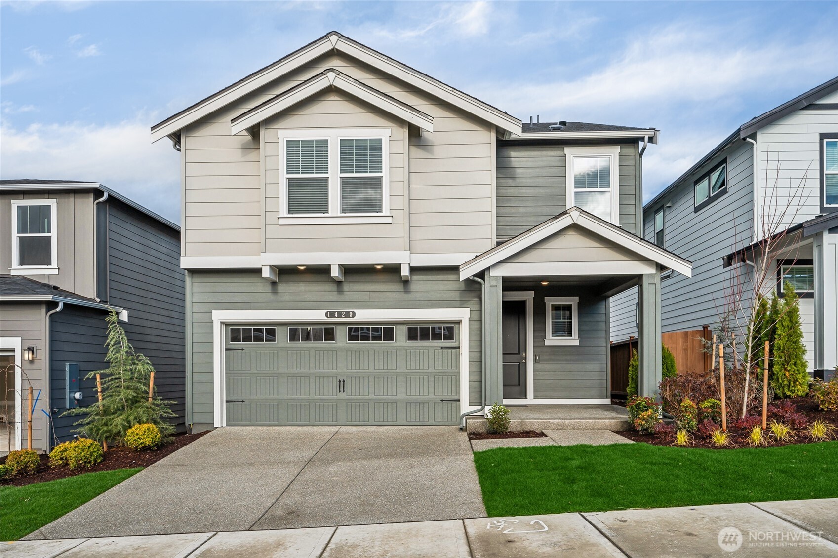 a front view of a house with a yard and garage