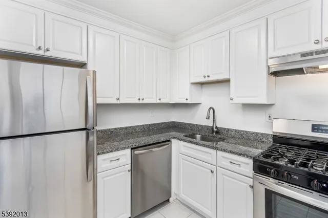 a kitchen with white cabinets and white appliances