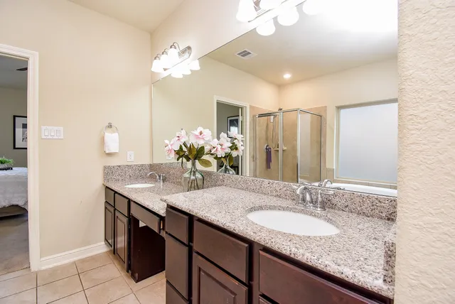 a bathroom with a granite countertop sink a large mirror and a shower