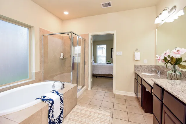 a bathroom with a tub sink and mirror