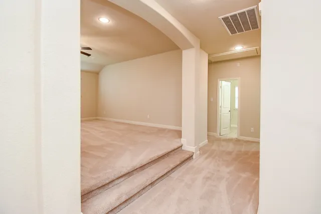 an empty room with windows and fan