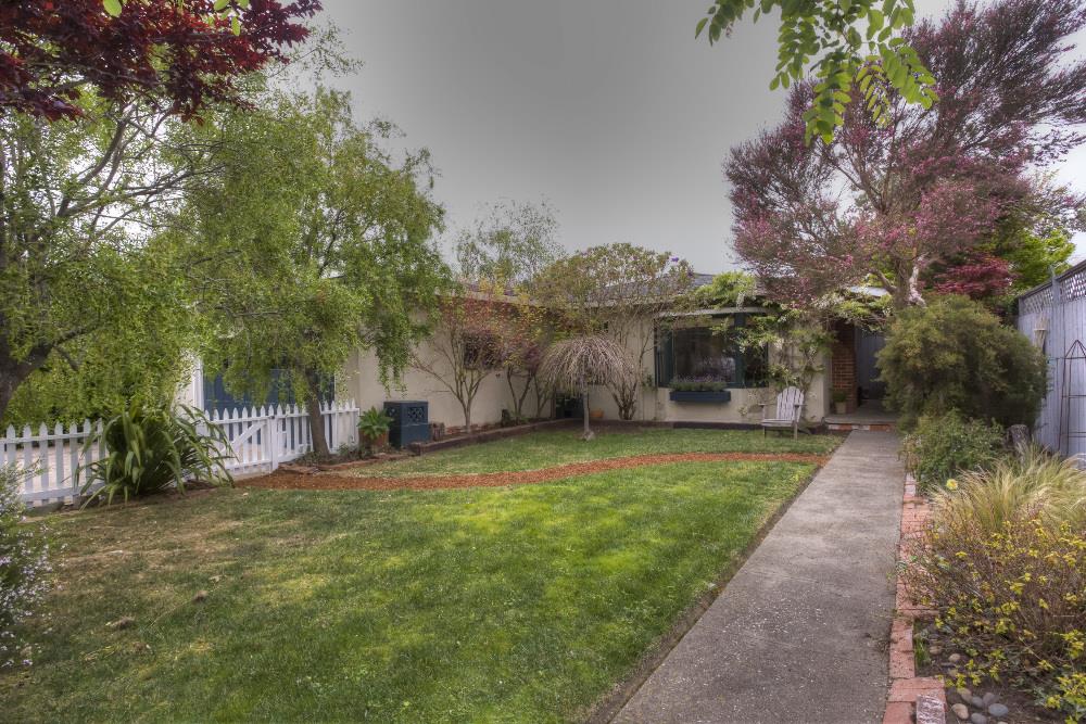 a view of a house with a yard and pathway