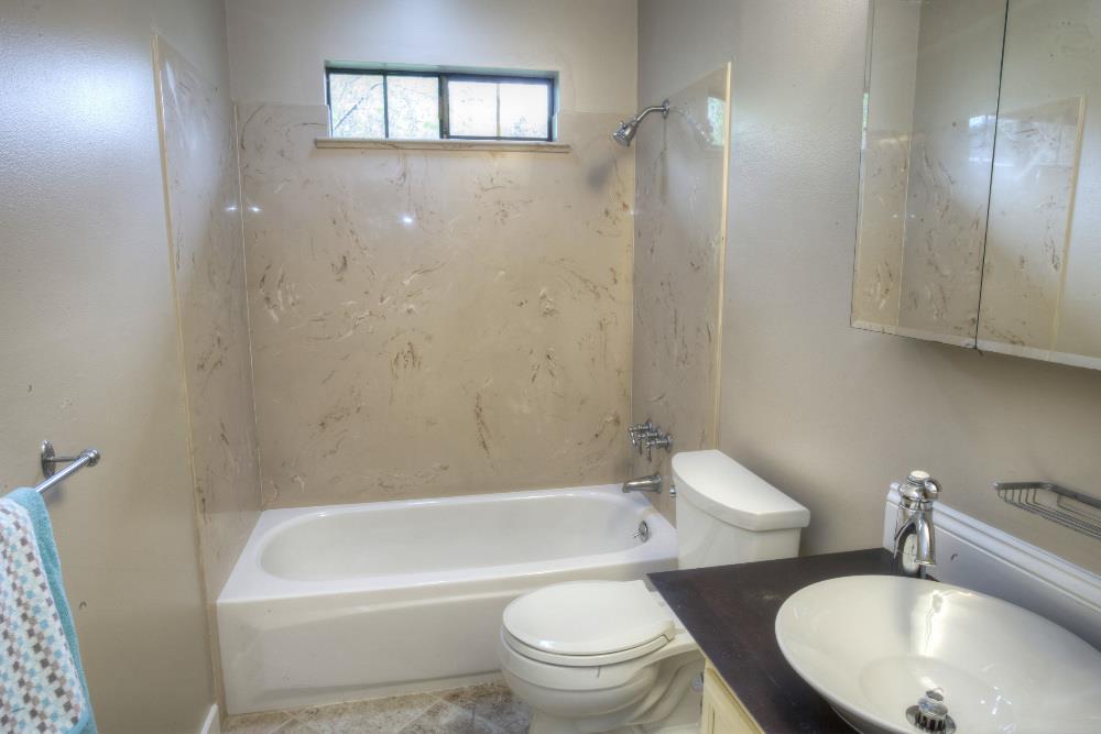 1452 Adobe Drive Pacifica, CA 94044 - Photo 12 of 23 a white toilet sitting next to a bathroom sink and tub