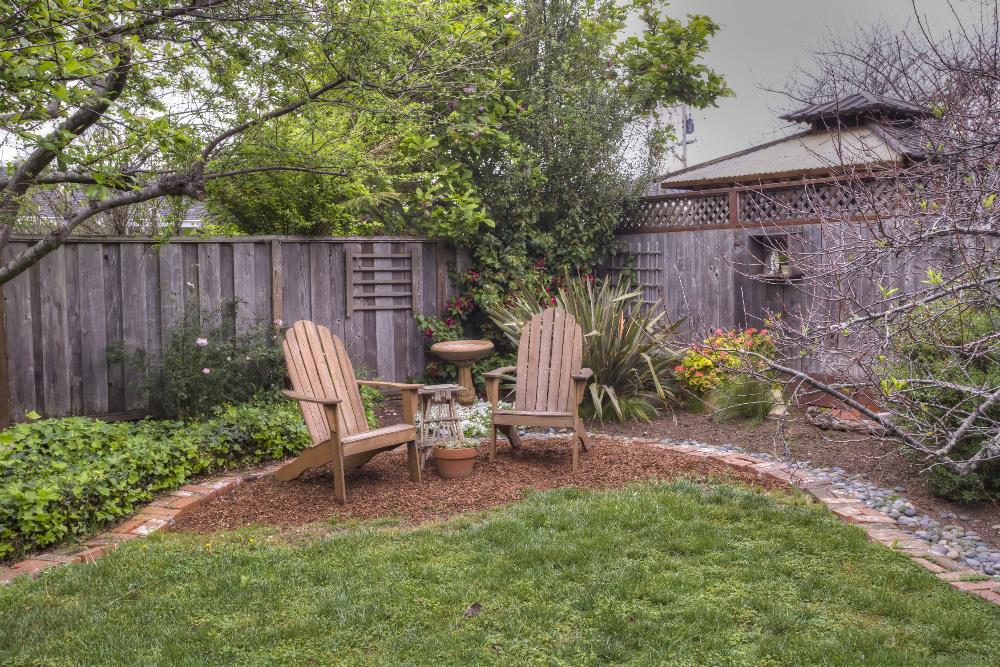 1452 Adobe Drive Pacifica, CA 94044 - Photo 21 of 23 a view of a backyard with chairs potted plants and wooden fence