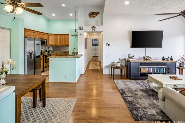 a living room with stainless steel appliances furniture and a flat screen tv