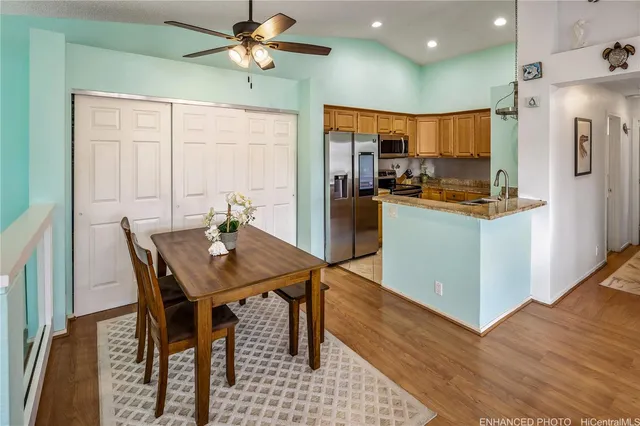 a kitchen with stainless steel appliances kitchen island granite countertop a table chairs and a refrigerator