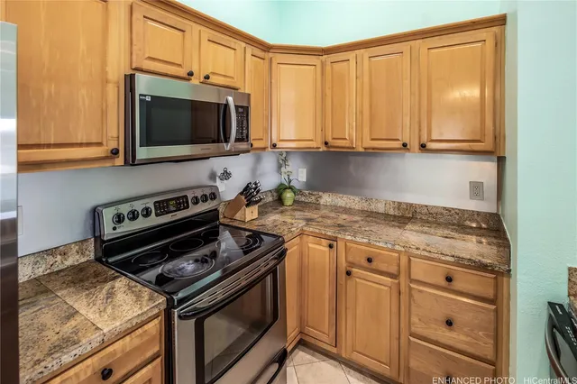 a kitchen with stainless steel appliances granite countertop a stove microwave and sink