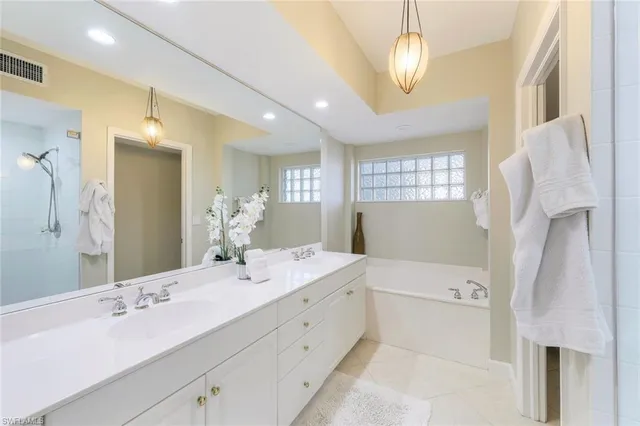 a bathroom with a double vanity sink mirror and shower