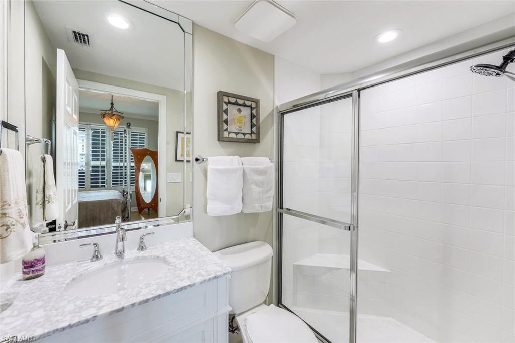 300 Dunes Boulevard, Unit 602 Naples, FL 34110 - Photo 13 of 18 a bathroom with a granite countertop sink toilet and shower