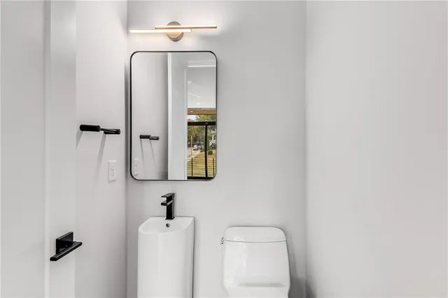 a bathroom with a toilet and a mirror