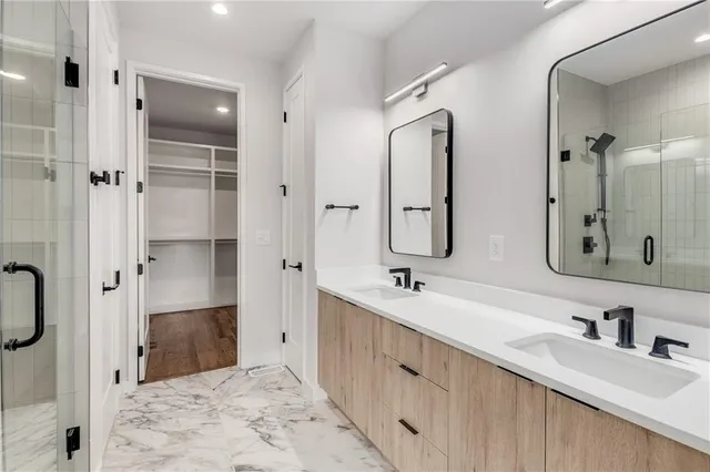 a bathroom with a double vanity sink mirror double and shower