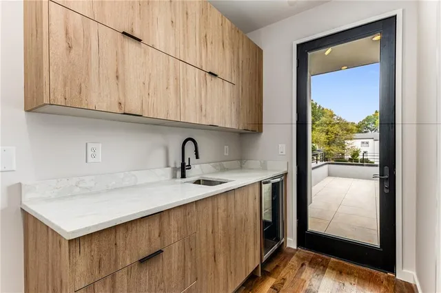 a kitchen with stainless steel appliances granite countertop a sink and a white cabinets with wooden floor