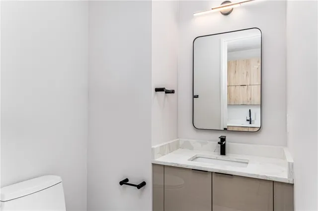 a bathroom with a granite countertop sink and a mirror