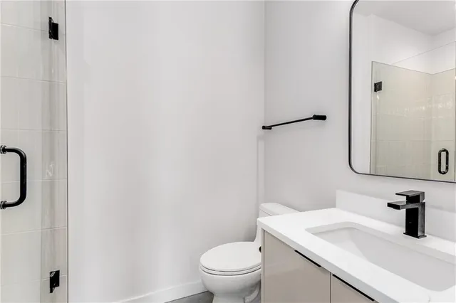 a large white kitchen with stainless steel appliances granite countertop a sink and cabinets