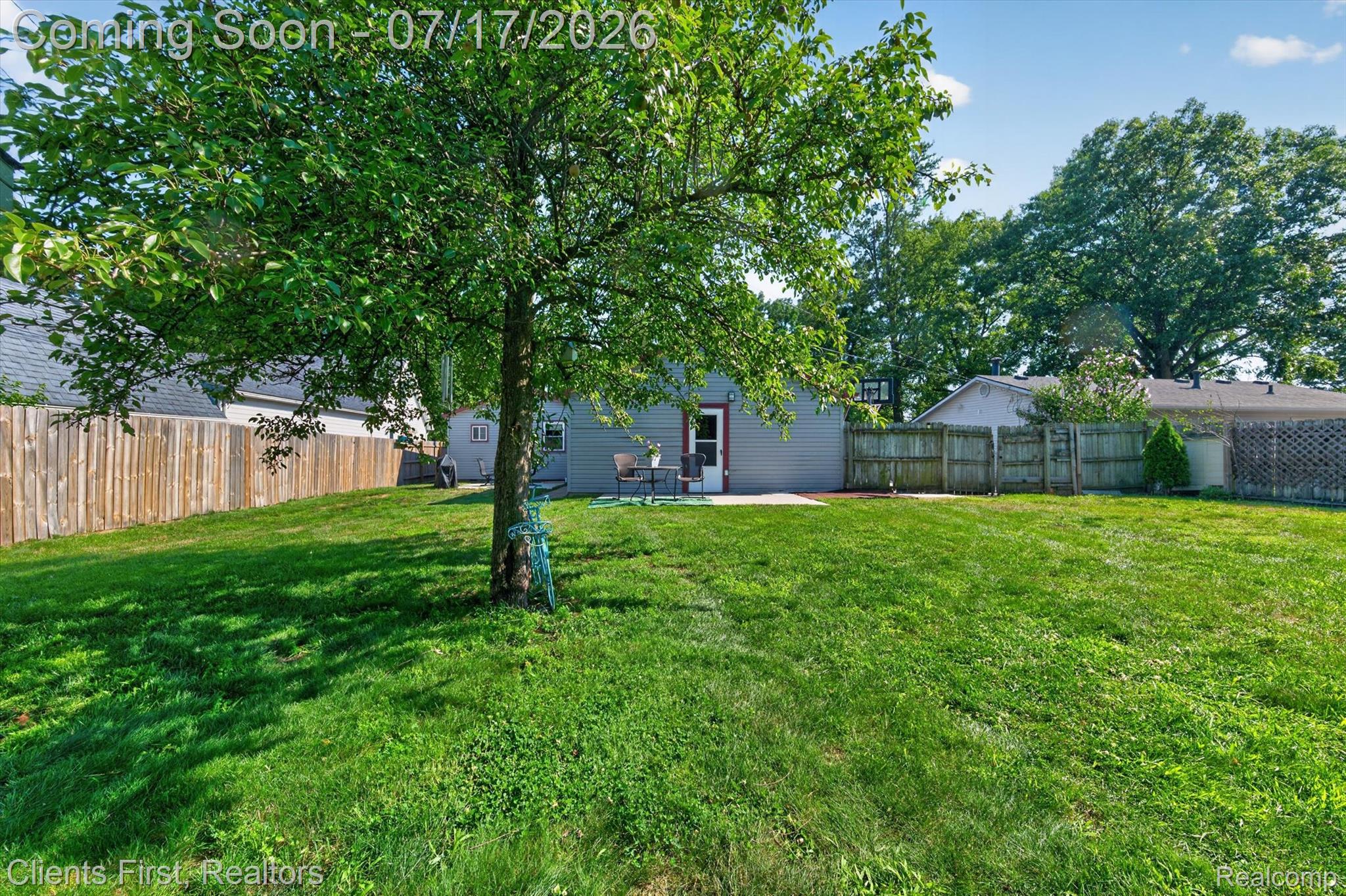 36852 Chase Street Romulus, MI 48174 - Photo 33 of 40 Expansive backyard featuring a mature tree, a privacy fence, and a concrete patio at the rear of the property