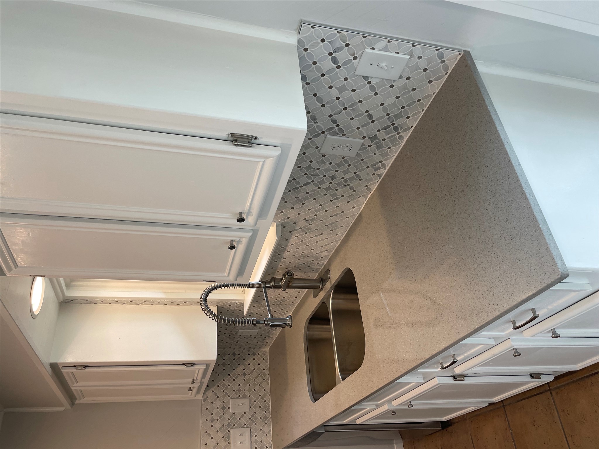 4619 Jinx Avenue, Unit A Austin, TX 78745 - Photo 3 of 21 Kitchen featuring light gray countertops, white cabinetry with silver-tone hardware, a double-basin stainless steel sink with a high-arch faucet, and a patterned tile backsplash
