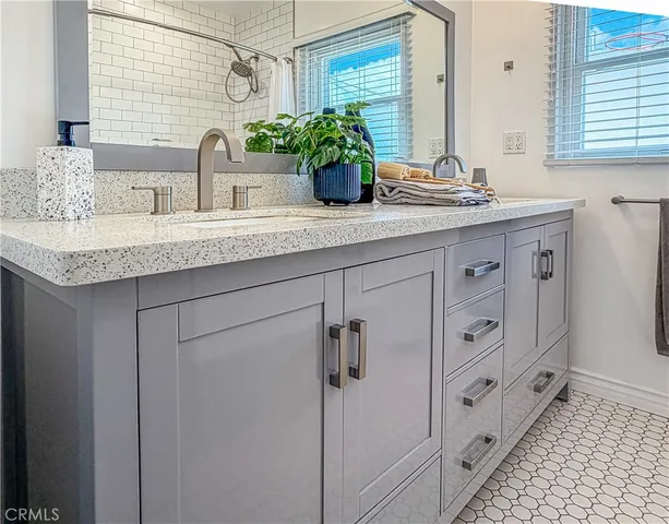a bathroom with double sink and a mirror