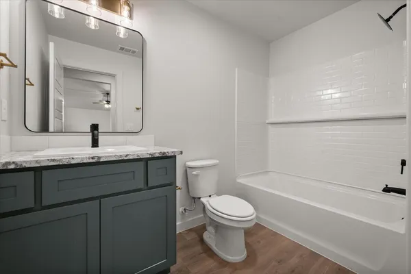 a bathroom with a granite countertop sink toilet and shower