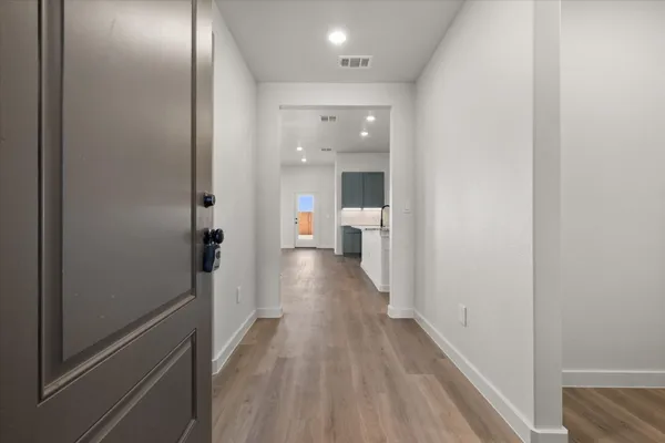 a view of a hallway with wooden floor