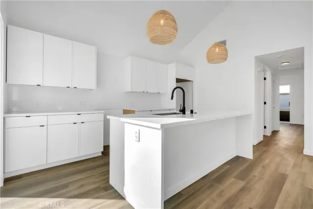 a kitchen with a sink cabinets and wooden floor