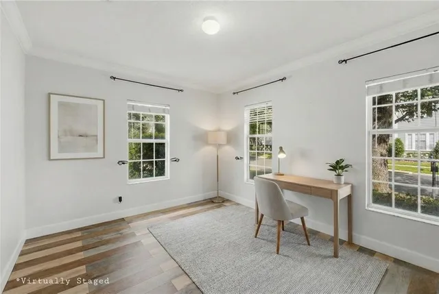 a view of a room with wooden floor lounge chair and windows