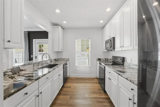 a kitchen with stainless steel appliances a stove a sink and a microwave
