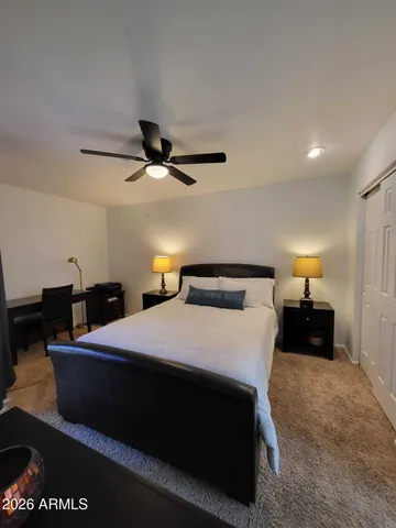 a bedroom with a large bed and a flat tv screen on dresser