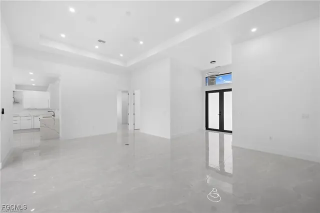 an empty room with white walls and windows