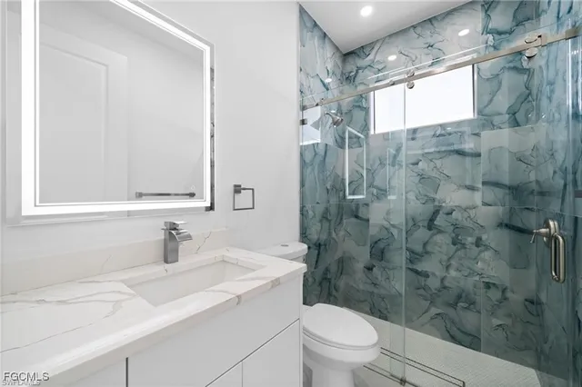 a bathroom with a sink toilet vanity and shower