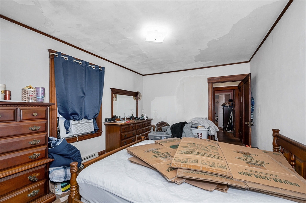 445 East Foster Street Melrose, MA 02176 - Photo 15 of 40 a bedroom with a bed and dresser with mirror