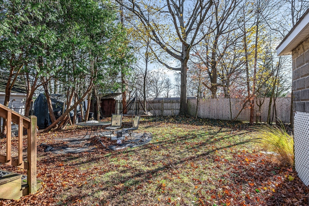 445 East Foster Street Melrose, MA 02176 - Photo 34 of 40 a backyard of a house with large trees and wooden fence