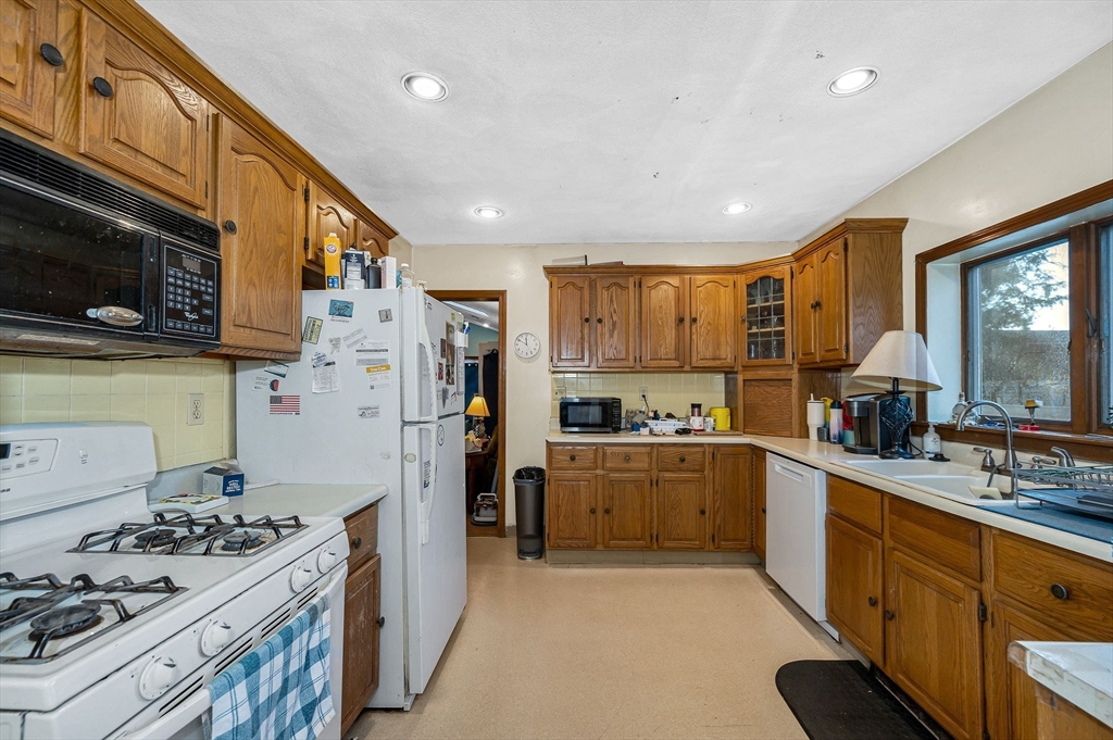 445 East Foster Street Melrose, MA 02176 - Photo 10 of 40 a kitchen with refrigerator a stove a sink dishwasher and wooden cabinets with wooden floor