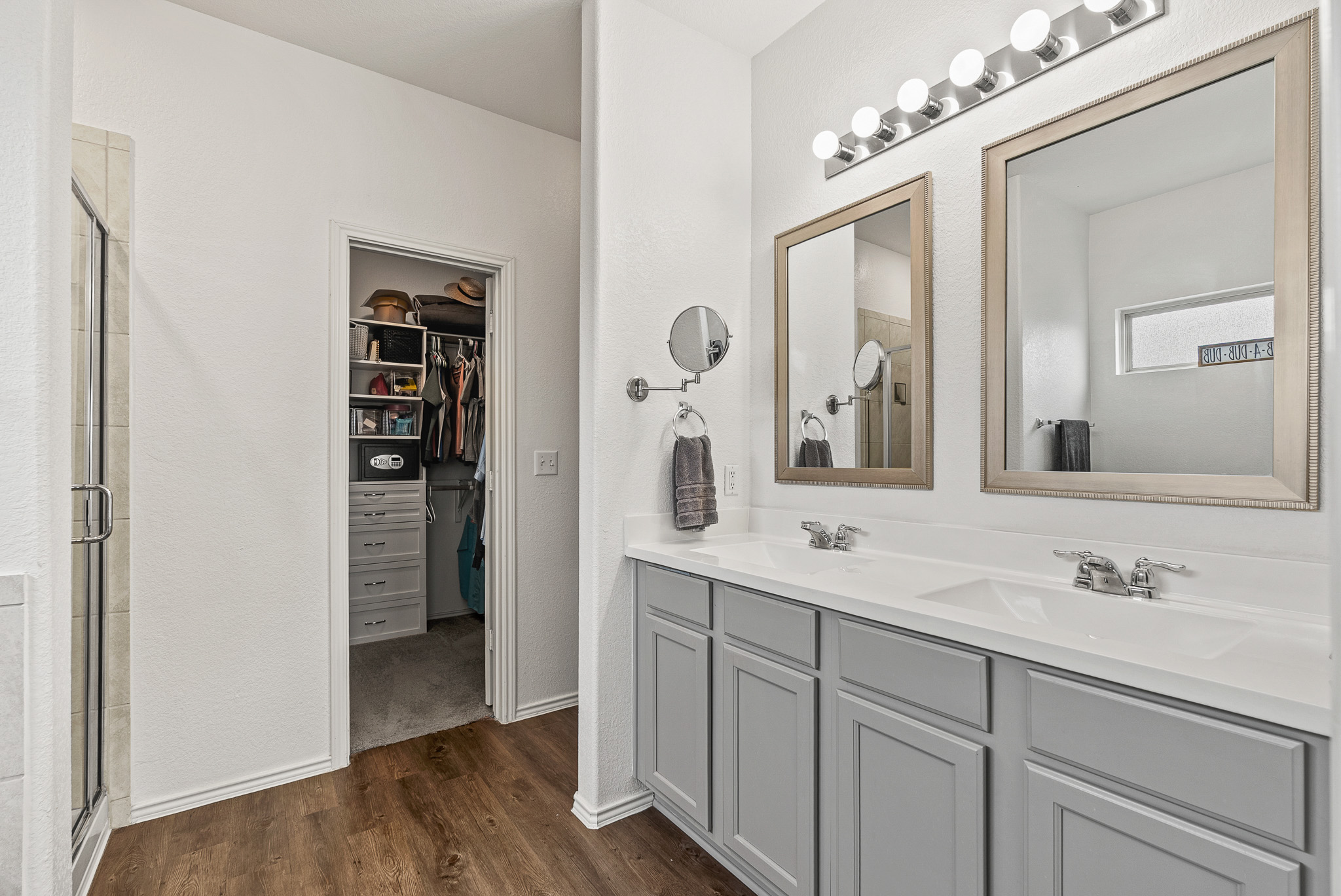 136 Copper Lane Kyle, TX 78640 - Photo 17 of 33 Full bath featuring a spacious closet, dark wood-type flooring, double vanity, and a shower stall