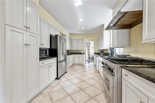 a kitchen with white cabinets and appliances