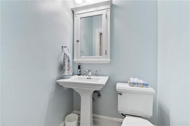 a bathroom with a toilet sink and mirror