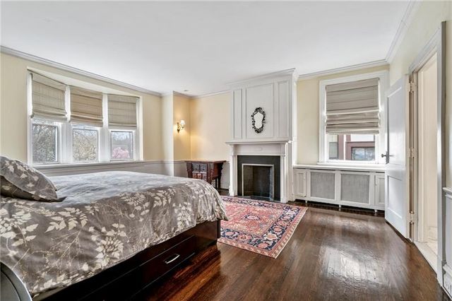 a bed sitting in a bedroom next to a window with a fireplace