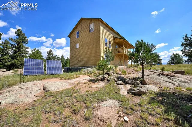 a view of backyard of house and car parked