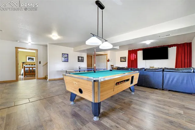 a room with pool table and windows