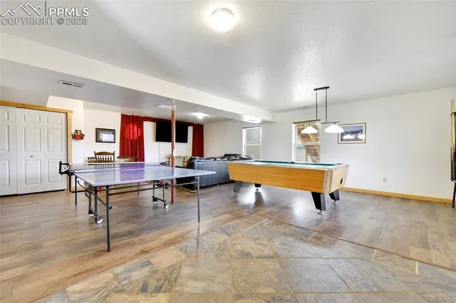 a living room with furniture pool table and rug