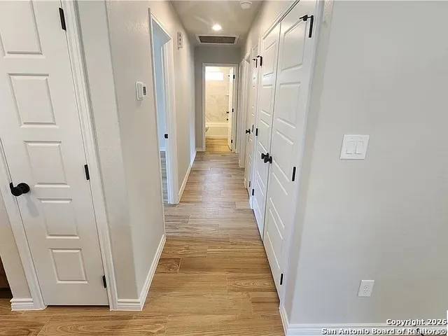 a view of a hallway with wooden floor and staircase
