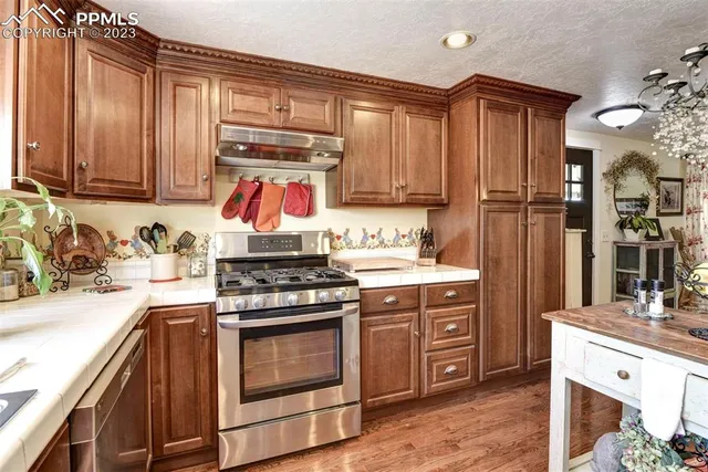 a kitchen with stainless steel appliances granite countertop a stove and a refrigerator