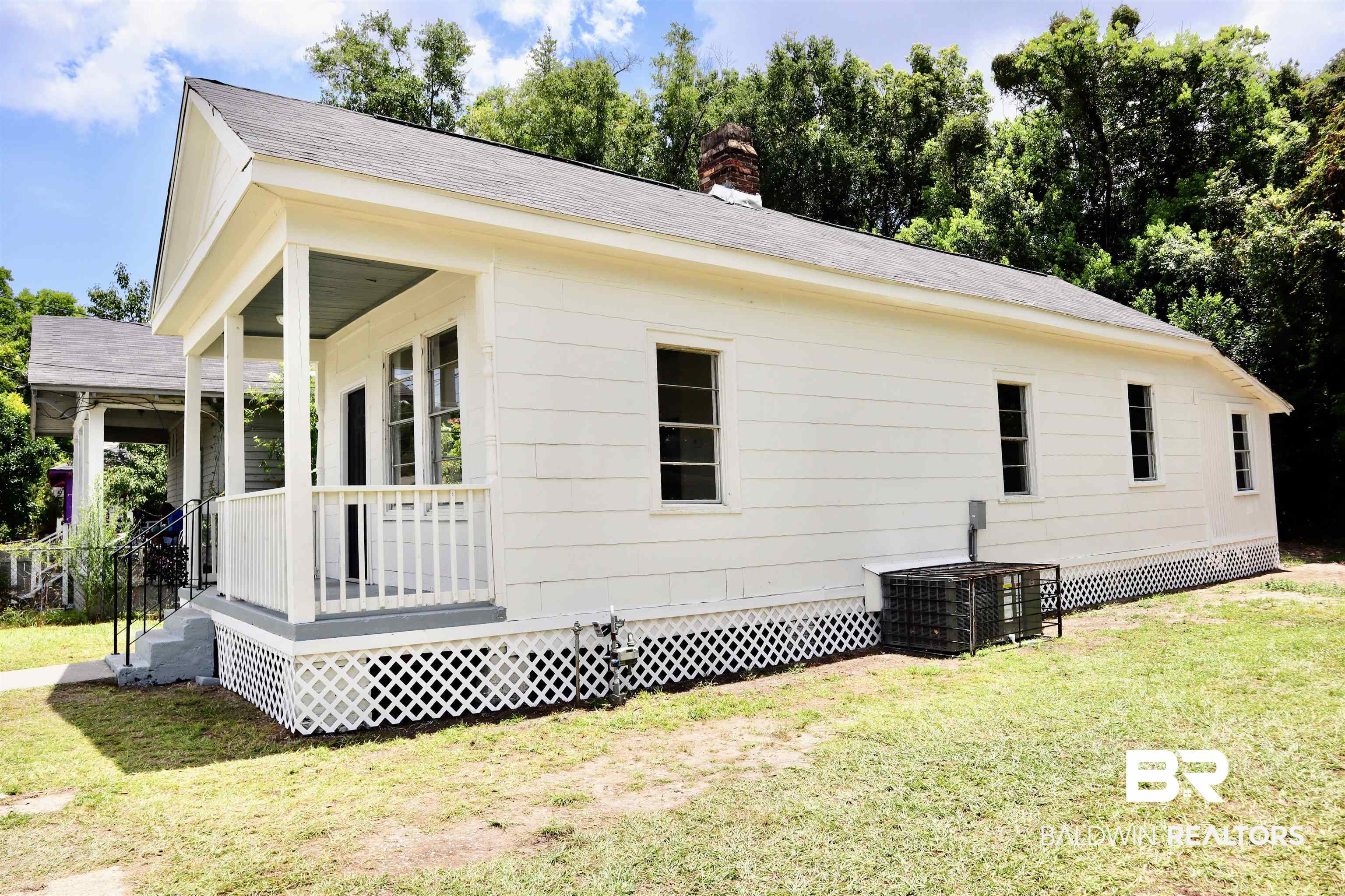 1009 Baltimore Street Mobile, AL 36605 - Photo 4 of 17 View of side of property with a yard, a chimney, a porch, and roof with shingles
