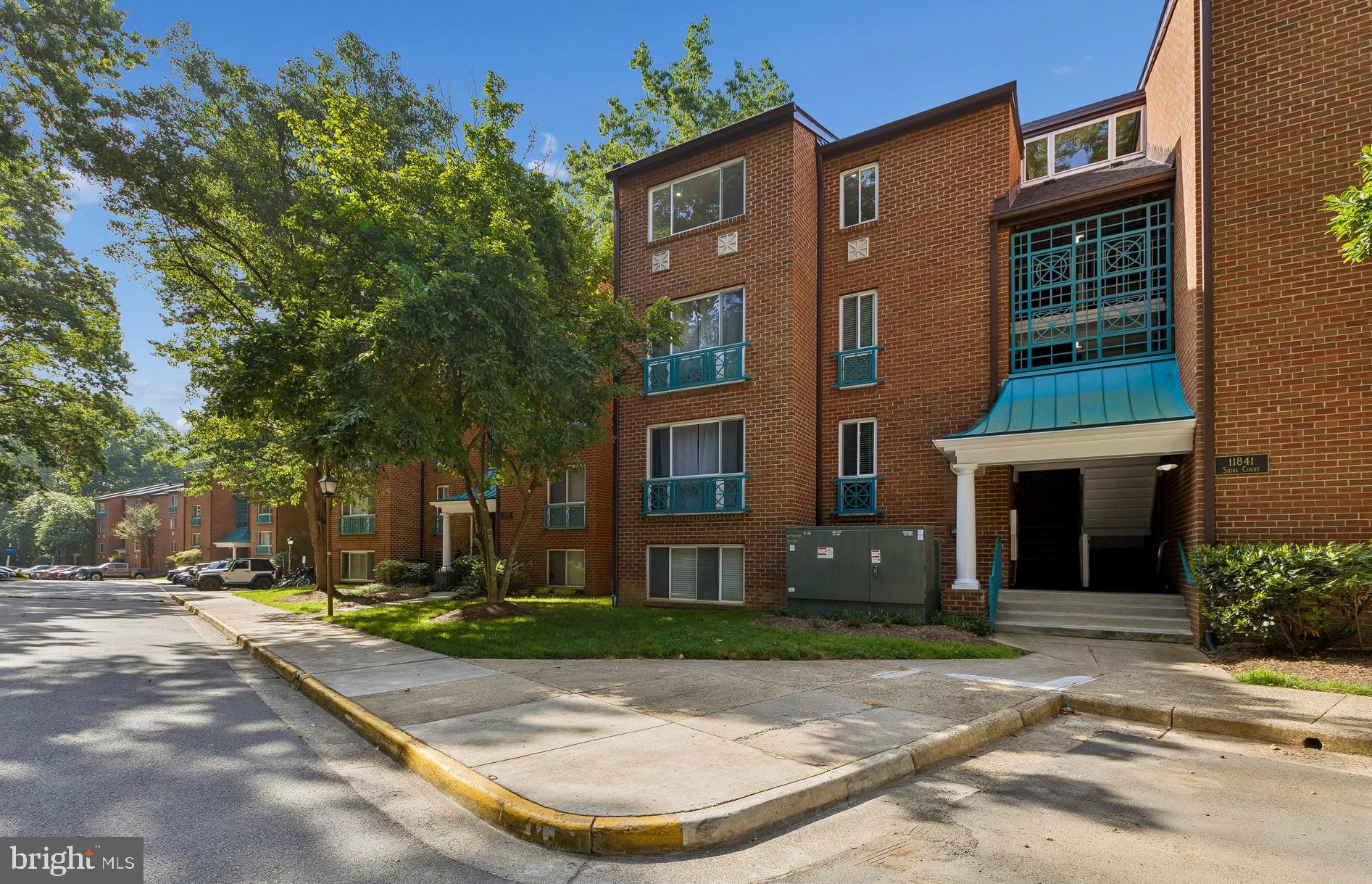 11841 Shire Court, Unit 31D Reston, VA 20191 - Photo 2 of 24 a view of a brick building next to a yard
