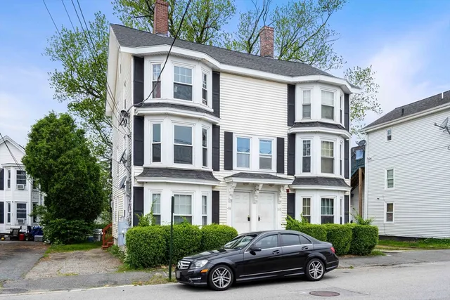a car parked in front of a white house