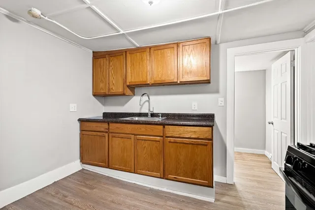 a kitchen with granite countertop wooden cabinets and a sink