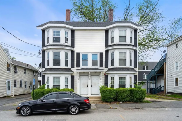 a car parked in front of a white building