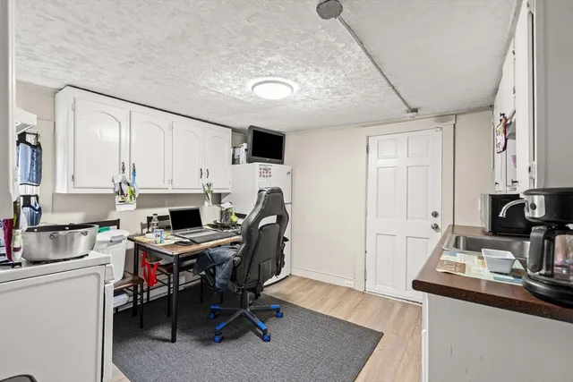 a view of a workspace with furniture and a window